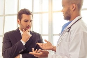 Homem com expressão de dúvida conversando com mécido